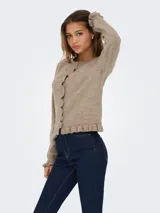 Cardigan de punto color beige melange, con cuello redondo, cierre frontal de botones y detalle de volados en el ruedo y los puños.