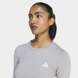 Remera de running manga larga Adidas, de corte ajustado y diseño cropped. Presenta cuello redondo, aberturas para los pulgares en los puños y logo de la marca reflectante en el pecho. Confeccionada con tecnología Climacool para la gestión de la humedad.