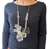 Collar largo con cadena dorada y colgante de resina con cubos translúcidos.