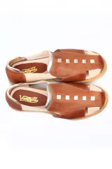 Zapato tipo sandalia plana de cuero liso en color rojo cereza con detalles en color crema. Presenta paneles laterales elásticos, suela dentada y diseño con aberturas.