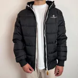 Campera inflada negra con capucha, cierre frontal blanco y puños elásticos acanalados. Presenta el logo de la marca Santa Barbara Outfitters bordado en el pecho.