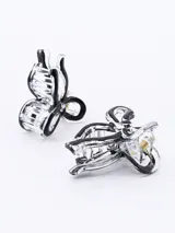 Set de dos pinzas para el pelo con forma de moño, color negro con borde transparente.