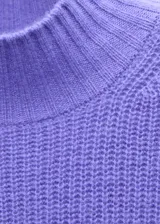 Jersey de punto de lana en color violeta, con cuello perkins y manga corta. Presenta un diseño recto y tejido de punto medio.