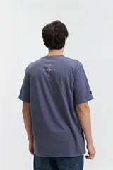 Remera de manga corta color marrón, con ajuste regular y escote redondo. Presenta un estampado frontal con texto en blanco formando un diseño circular.