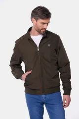 Campera liviana de color verde grisáceo, con cierre frontal, cuello alto y puños elásticos. Presenta un pequeño parche con logo en el pecho.