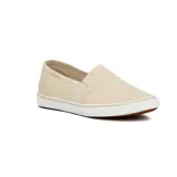 Zapatillas slip-on color beige de lona, con elástico en los laterales y suela blanca.