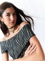 Top negro con estampado floral, escote off-shoulder, corte cruzado y mangas cortas.