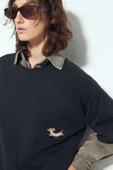 Remerón de manga corta color terracota con efecto gastado, silueta amplia y bolsillo aplicado con bordado de perro salchicha.