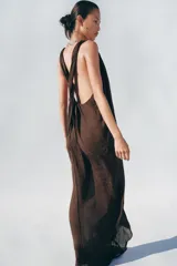Vestido midi de escote en pico con tirantes anchos cruzados en la espalda, confeccionado en tejido jacquard con textura sutil.