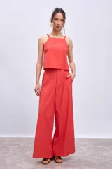 Pantalón palazzo color coral, de tiro alto y corte amplio.