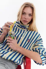 Chaqueta bomber de algodón con estampado a cuadros en tonos azules, amarillos y marrones, cuello alto y cierre frontal descentrado con botones. Cuenta con mangas abullonadas y puños elásticos.