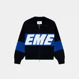 Campera de punto negra con franja azul y letras blancas con la palabra 'EME' en el pecho. Tiene cuello polo, cierre frontal con cremallera y corte oversize.