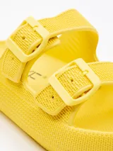 Sandalias amarillas de goma con plataforma de 4 cm y dos tiras con hebilla sobre el empeine.