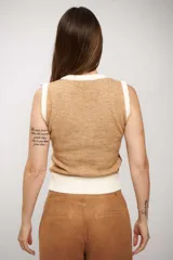 Chaleco de punto sin mangas con escote en V, diseño de bloques de color en tonos tierra (marrón, beige y crema) y terminaciones acanaladas en cuello, sisas y ruedo.