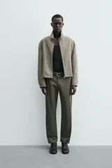 Pantalón chino de corte regular fit, confeccionado en tejido de algodón con elasticidad. Presenta bolsillos frontales, bolsillos traseros de vivo y cierre frontal con cremallera y botón.