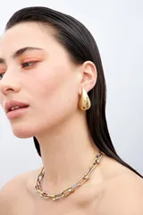 Aros de acero quirúrgico en diseño de gota tridimensional de gran tamaño y acabado dorado brillante.