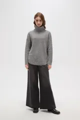 Polera de tejido de punto con cuello alto, diseño holgado y mangas largas. Presenta una textura de relieve tipo waffle en color natural.