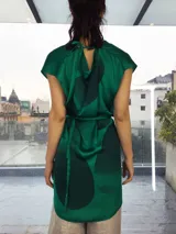 Vestido fucsia con estampado abstracto en tonos borgoña, corte midi, sin mangas, con escote en la espalda y lazo en la cintura.