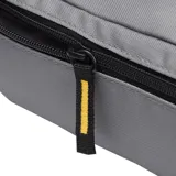 Riñonera Caterpillar (CAT) color gris medio, con compartimento principal con cierre de cremallera y tirador de tela con el logo de Caterpillar. Presenta un parche con el logo CAT en el frente y cierre con cremallera amarilla.