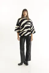 Sweater de punto con cuello alto y manga corta, con estampado de cebra en blanco y negro.