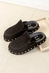 Zuecos tipo mule de cuero gamuzado negro, con plataforma forrada y detalle de tachas plateadas en el contorno. Presentan una plantilla con el logo bordado.