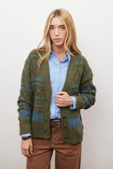 Sacon de tejido de punto grueso con diseño de ochos y rayas horizontales en contraste. Presenta cuello en V, cierre frontal con botones oscuros y mangas largas con puños acanalados.