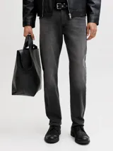 Jean tapered de hombre color negro con acabado lavado, tiro bajo y diseño clásico de cinco bolsillos.