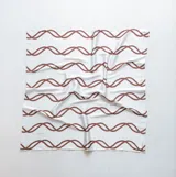 Pañuelo de seda blanco con estampado de líneas curvas en color verde lima, y texto sutil en la tela.