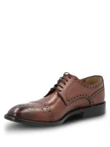 Zapato de vestir tipo Oxford con diseño brogue, confeccionado en cuero vacuno de color marrón. Presenta cierre mediante cordones, puntera redondeada con detalle de perforaciones decorativas y suela mixta de cuero y goma.