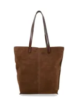 Cartera tipo tote bag de gamuza color marrón, con asas largas de cuero liso y costuras visibles en el centro.