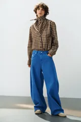 Jeans de tiro medio estilo balloon en color negro, con diseño de cinco bolsillos, trabillas para cinturón y cierre frontal con cremallera y botón metálico.