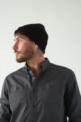 Camisa de hombre color beige con efecto stone wash, corte regular, cuello clásico, cierre frontal con botones, dos bolsillos con solapa abotonada en el pecho y mangas largas con puños abotonados.