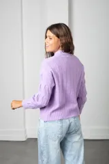Sweater de punto color lila, con cuello redondo y diseño trenzado en relieve. Presenta mangas largas con puños acanalados y un corte holgado.