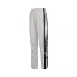 Pantalón Adidas Adibreak de color gris, con cintura elástica y una banda lateral negra con botones a presión y las clásicas tres franjas blancas de la marca. Incluye el logo de Adidas Originals y etiqueta bordada en la parte inferior de la pierna.