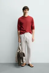 Pantalón de corte regular fit confeccionado en tejido mezcla de algodón, con cintura elástica ajustable mediante cordón, bolsillos laterales y bolsillos traseros de vivo.