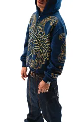 Hoodie azul con cierre y bolsillos laterales, con estampado dorado de hojas de acanto en el frente y las mangas.