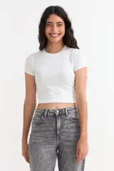 Remera crop de manga corta y cuello redondo acanalado, confeccionada en tejido de algodón elastizado con textura en rib.