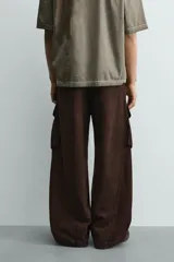 Pantalón cargo de corte relajado confeccionado en tejido de algodón con efecto lavado. Presenta cintura con pliegues frontales, bolsillos laterales con solapa en las perneras, bolsillos frontales y bolsillos traseros con solapa. Cierre frontal con cremallera y botón.