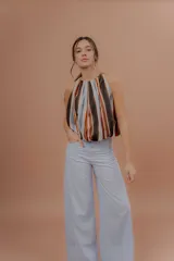 Musculosa de algodón con cuello redondo, sin mangas y diseño abullonado en la parte inferior. Presenta un estampado de rayas verticales en tonos marrones, naranjas, celestes y negros.