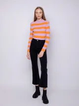 Polera de tejido de punto con diseño a rayas horizontales amarillas y violetas, de manga larga y cuello alto.