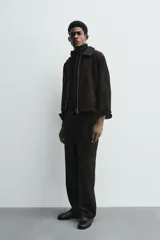 Sobrecamisa de corte cropped confeccionada en terciopelo con elasticidad. Presenta cuello solapa, cierre frontal con cremallera metálica, bolsillos de vivo en la cadera y mangas largas con puños abotonados.