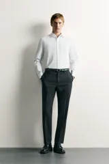 Camisa de corte regular fit color celeste, confeccionada en tejido fácil de planchar. Cuenta con cuello italiano abierto, manga larga con puño abotonado y cierre frontal con botonadura.
