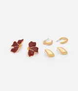 Kit de tres pares de caravanas de metal, compuesto por un par con diseño de flores esmaltadas en color bordó, un par de argollas doradas y un par con formato orgánico.