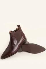 Bota tipo Chelsea de cuero vacuno con textura de efecto croco en color marrón oscuro. Presenta paneles elásticos laterales y una tira de ajuste en la parte posterior, con un taco bajo cuadrado.