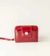 Billetera pequeña de cuero sintético color azul con textura croco, cierre perimetral con cremallera y correa de mano extraíble.