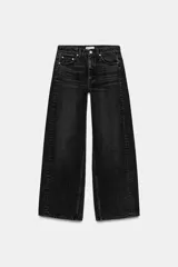 Jeans de tiro medio color negro con efecto lavado, de cinco bolsillos y pierna ancha tipo wide leg. Cierre frontal con cremallera y botón metálico.