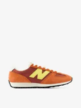 Championes urbanos New Balance modelo U471, con diseño inspirado en el running de los años 70. Presenta una combinación de colores naranja y bordó con el logo lateral en amarillo. Confeccionados con paneles de ante y material sintético, cuentan con entresuela de EVA y suela de goma con diseño de espiga.