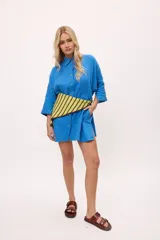 Vestido camisero azul vibrante, de manga larga y corte suelto, con botones a contratono y detalle de zigzag en el tejido.