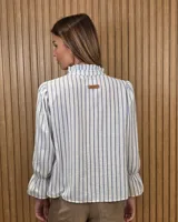 Blusa de algodón color azul, de corte suelto, con mangas largas abullonadas y cuello con volados y escote en V.