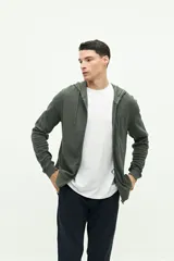 Campera de felpa color verde militar, con cierre frontal, capucha ajustable con cordones y logo estampado en el pecho.